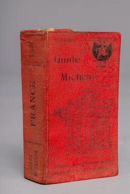 un livre rouge posé sur une table blanche