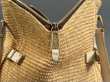 sac à main tissé beige et blanc avec des fermetures éclair sur fond gris