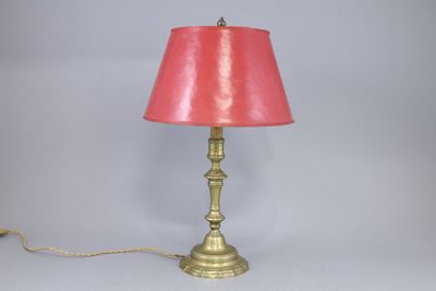 a lamp that is on a table with a pink shade on it