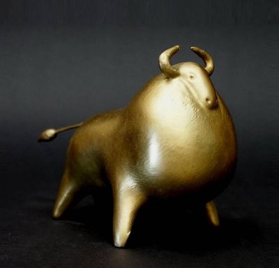 une figurine en or représentant un taureau sur fond noir