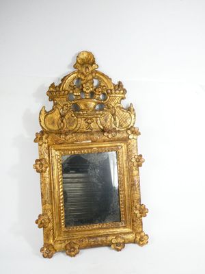a mirror on the wall with a gold frame