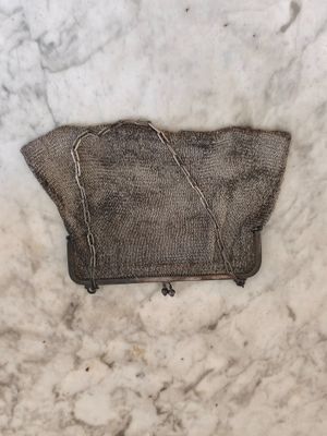 un sac à main en tricot marron posé sur un plan de travail en marbre