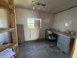 a room that has a desk and shelves in it