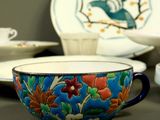 a bowl and a plate with a bird on it on a table