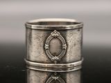 a close up of a silver ring on a table with a reflection