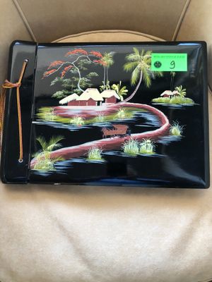 un plateau noir orné d'une peinture, posé sur une chaise