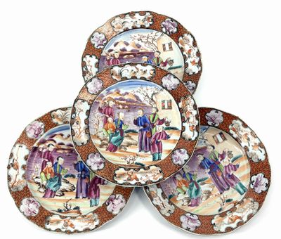 four plates with a picture of people on them on a white surface