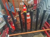 orange and white traffic cones are sitting in a pile next to a pile of chairs
