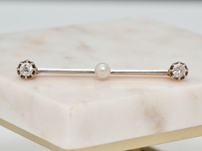un gros plan d'une barre de musculation surmontée d'une perle, posée sur une table en marbre