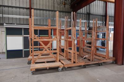 une grande structure en bois dans un entrepôt, avec de nombreuses pièces de bois posées sur des palettes