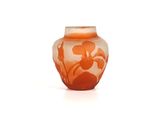 un vase orange orné d'un motif floral