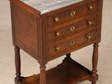 an old wooden table with a marble top sitting on a floor