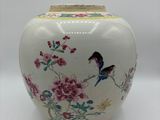 un vase blanc sur lequel sont peints un oiseau et des fleurs