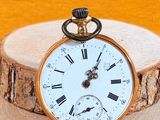 une montre de poche en or avec des chiffres romains