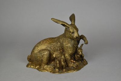 une image représentant une figurine de lapin en or posée sur une surface blanche
