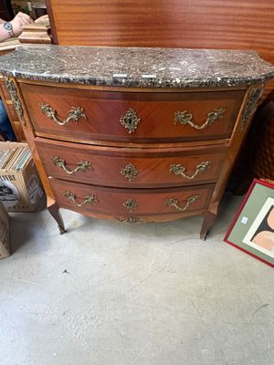 une commode en marbre dans une pièce