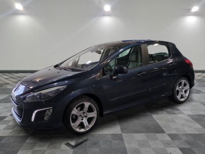 une voiture bleue est garée dans une pièce au sol à carreaux