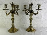 pair of antique brass candelabs with birds on each of them