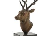 sculpture of a deer head with antlers on a wooden base