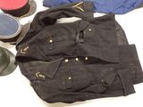 a black jacket, hat, and other items on a table