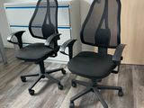 deux chaises de bureau noires placées l'une à côté de l'autre sur un parquet