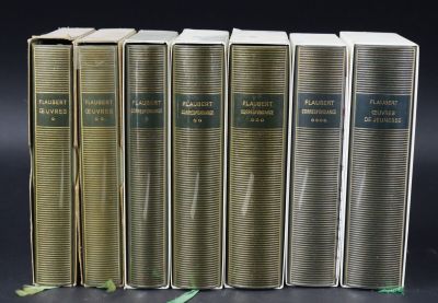 six books are lined up in a row on a black surface