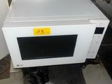 un micro-ondes posé sur un meuble dans la cuisine