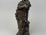 a bronze statue of a woman with a bird on her shoulder