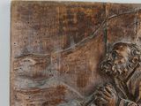 carvings of a man sitting on a bench with a bird in his hand