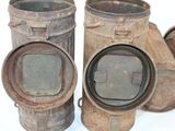 three old metal containers sitting next to each other on a white surface