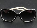 des lunettes de soleil noires et blanches posées sur une table noire, sur fond noir