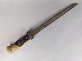 an old knife with a wooden handle sitting on a white surface