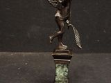 a statue of an angel holding a clock on a pedestal