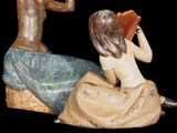 a figurine of a man and a woman sitting on a rock
