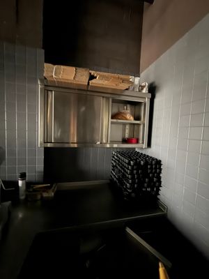 une cuisine équipée d'une cuisinière, d'un évier et d'étagères