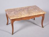 une table basse avec un plateau en marbre posée sur un piètement en bois