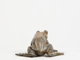 a statue of a frog that is sitting on the ground