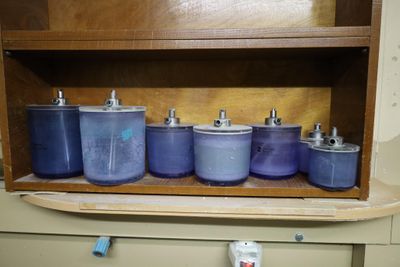 many blue pots and pans on a shelf in a cabinet