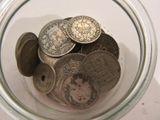 a glass jar filled with coins on a table