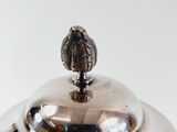 a silver plate with a bird on top of it