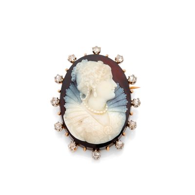 Une broche représente une femme en robe blanche.