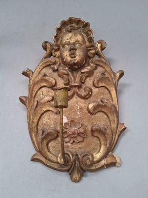 une plaque en or sur laquelle sont gravés un visage et une épée
