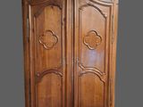 une armoire ancienne en bois, avec un dessus sculpté et deux portes
