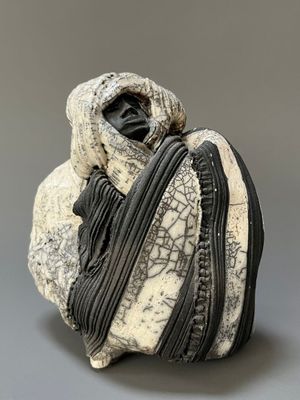 a black and white sculpture of a person holding a bag