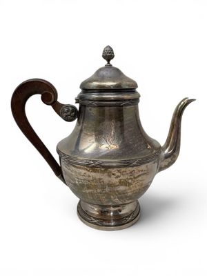 an old silver teapot with a wooden handle on a white background