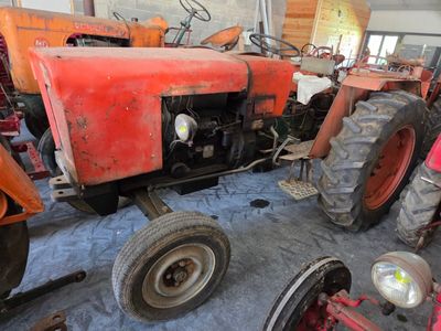 a red tractor that is parked in a garage