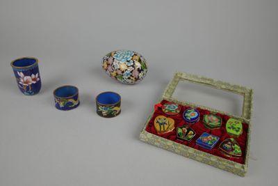 a small box with three cups and a vase on the table