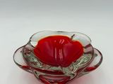 a glass bowl with a red flower inside of it