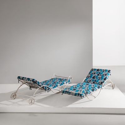 deux chaises longues avec des coussins bleus, posées sur une plate-forme blanche