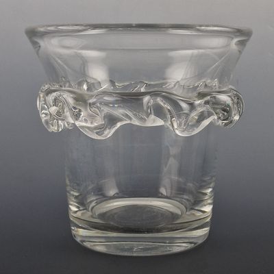 a clear glass vase with a handle on a table